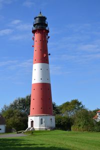 Der Leuchtturm, rot und wei&szlig; gestrichen, erhebt sich stolz &uuml;ber dem Meer und dient als Orientierungspunkt f&uuml;r Seefahrer.